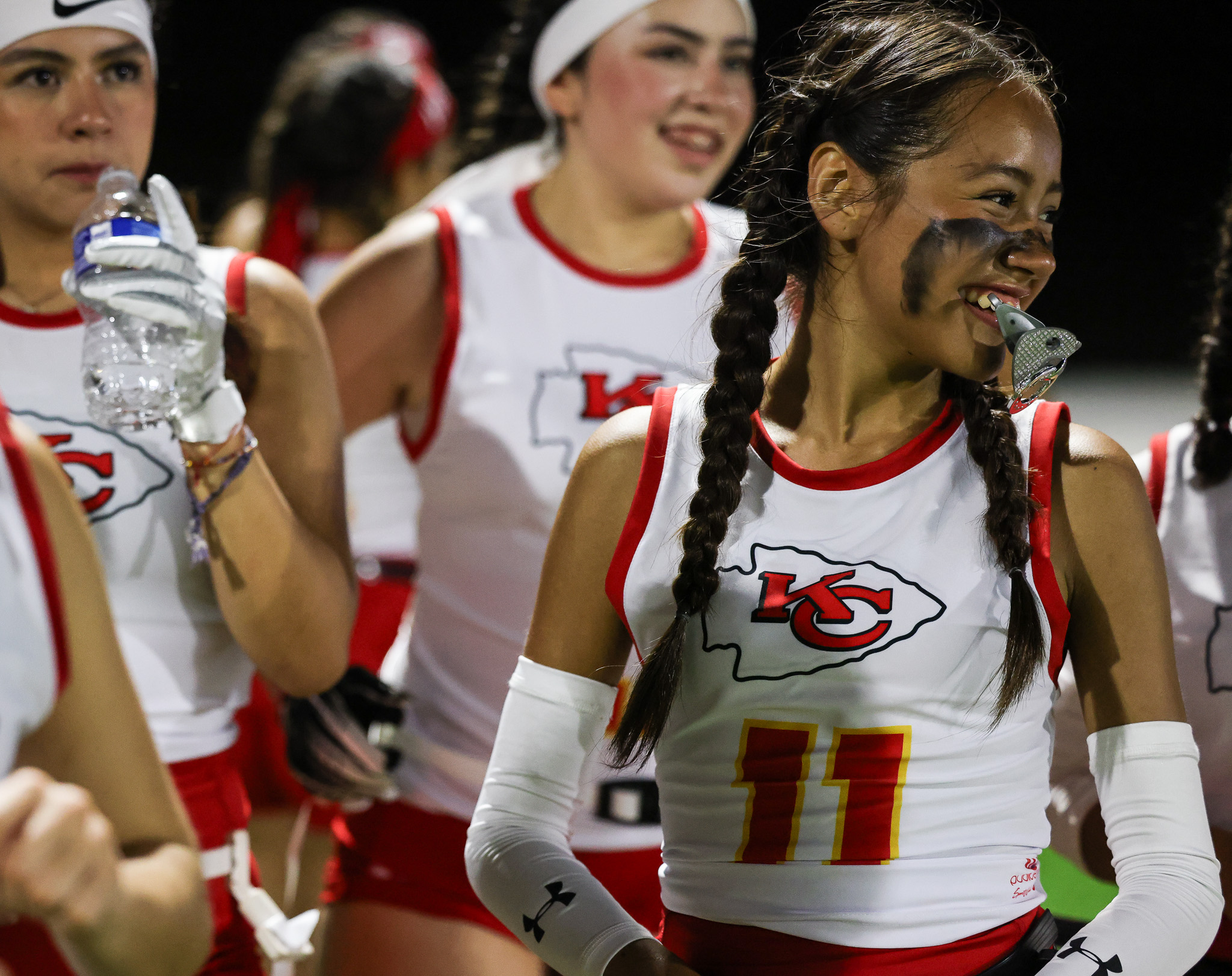 Jugadoras de flag football femenil con uniforme de los Kansas City Chiefs sonriendo durante el torneo NFL FLAG Championships.