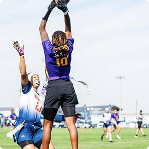 Player jumping to catch the football during a flag football game.
